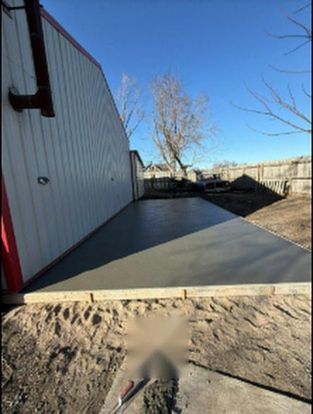 Fresh concrete apron poured along a metal building by Twins Concrete in Nebraska