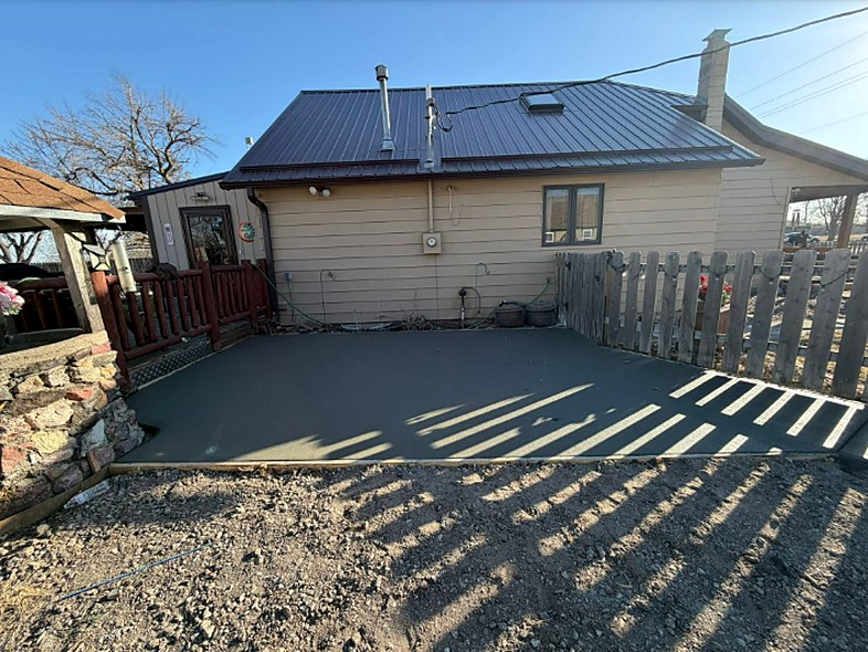 Wide backyard concrete patio poured behind a Nebraska home by Twins Concrete